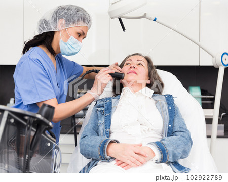 Elderly woman getting facial procedure in aesthetic medicine office 102922789