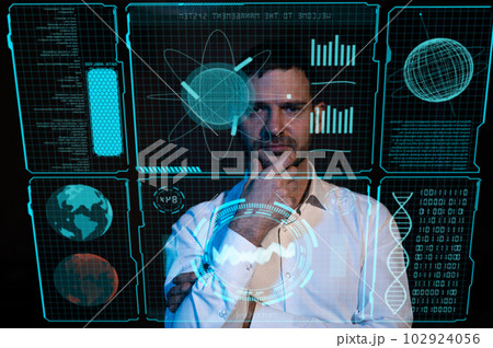 Caucasian man looking in the dark at a virtual screen.  102924056