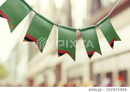 A garland of Zambia national flags on an abstract blurred background 102925988