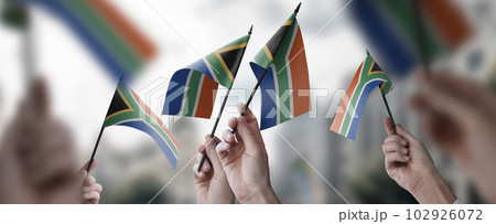 A group of people holding small flags of the South Africa in their hands A group of people holding small flags of the South Africa in their hands 102926072