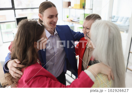 Corporate employees hug to support and inspire in office 102926627