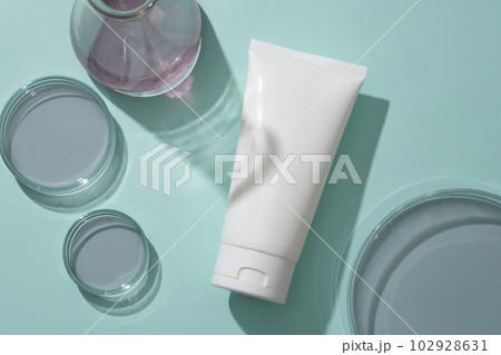 Flat lay of unlabeled cosmetic plastic bottle on blue background with lab glassware containing blueberry essence. Mockup for cosmetic from blueberry ingredient. Flat lay of unlabeled cosmetic plastic bottle on blue background with lab glassware containing blueberry essence. Mockup for cosmetic from blueberry ingredient. 102928631