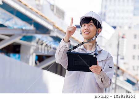 ビジネス　建設現場でタブレットを見る作業服の男性 102929253