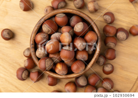 Hazelnuts in a bowl on wooden background. Top view Hazelnuts in a bowl on wooden background. Top view 102930694