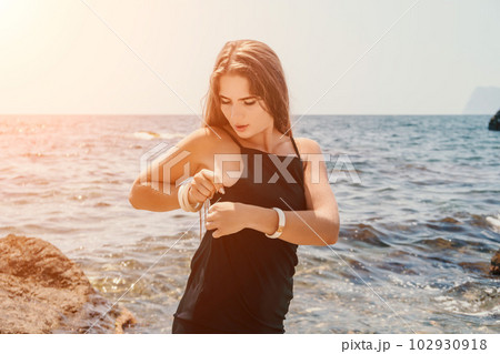Woman summer travel sea. Happy tourist in hat enjoy taking picture outdoors for memories. Woman traveler posing on the beach at sea surrounded by volcanic mountains, sharing travel adventure journey Woman summer travel sea. Happy tourist in hat enjoy taking picture outdoors for memories. Woman traveler posing on the beach at sea surrounded by volcanic mountains, sharing travel adventure journey 102930918