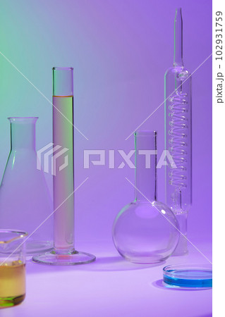 Blank space in the middle of several laboratory glassware containing fluid in many colors. Concept of science, production of cosmetics Blank space in the middle of several laboratory glassware containing fluid in many colors. Concept of science, production of cosmetics 102931759