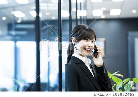 女性　電話　スマホ　オフィス　笑顔 102932468