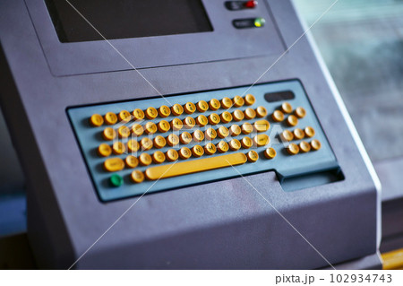 Built-in color keyboard with yellow mechanical buttons for the computer of a large industrial knitting machine with a built-in monitor next to it 102934743