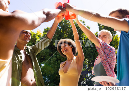 Happy diverse group of friends making a toast in garden 102938117