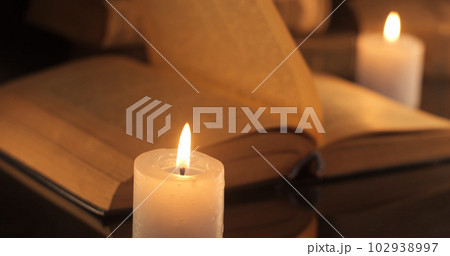 An old book and burning candles An old book and burning candles 102938997