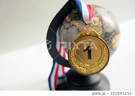 Gold medal in the foreground on red blue white ribbon Gold medal in the foreground on red blue white ribbon 102943254