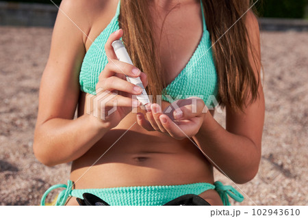 An independent child checks the level of glucose in the blood while sitting on the beach. An independent child checks the level of glucose in the blood while sitting on the beach. 102943610