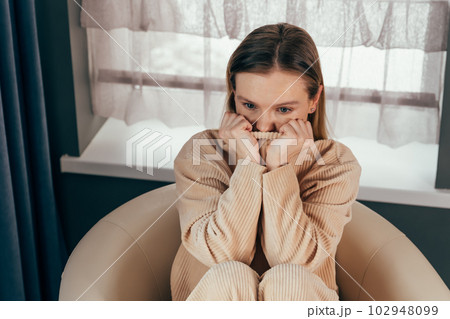 Sad thoughtful girl sits on chair feels depressed, offended or lonely. 102948099