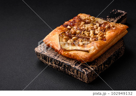 Delicious fresh sweet pie or pizza with pear, brie cheese, honey and nuts Delicious fresh sweet pie or pizza with pear, brie cheese, honey and nuts 102949132
