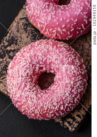Delicious fresh sweet donuts in pink glaze with strawberry filling 102949159
