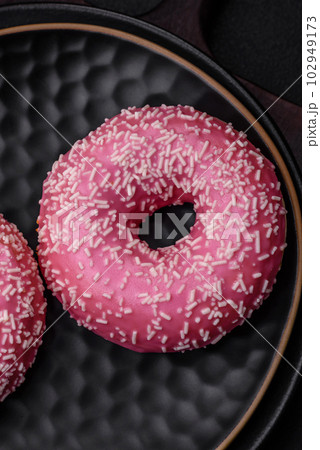 Delicious fresh sweet donuts in pink glaze with strawberry filling Delicious fresh sweet donuts in pink glaze with strawberry filling 102949173