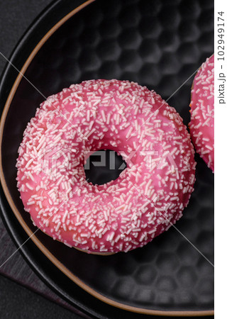 Delicious fresh sweet donuts in pink glaze with strawberry filling Delicious fresh sweet donuts in pink glaze with strawberry filling 102949174