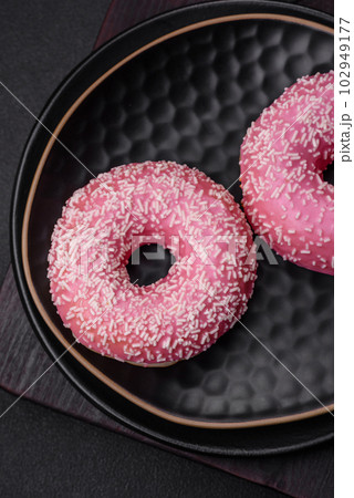 Delicious fresh sweet donuts in pink glaze with strawberry filling 102949177