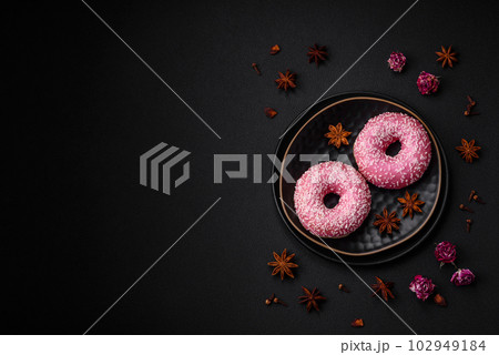 Delicious fresh sweet donuts in pink glaze with strawberry filling Delicious fresh sweet donuts in pink glaze with strawberry filling 102949184