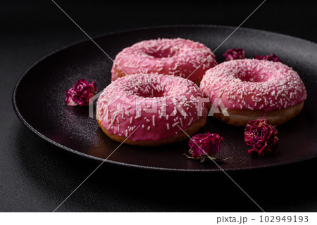 Delicious fresh sweet donuts in pink glaze with strawberry filling Delicious fresh sweet donuts in pink glaze with strawberry filling 102949193