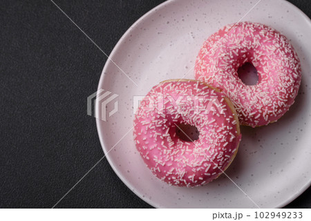 Delicious fresh sweet donuts in pink glaze with strawberry filling 102949233