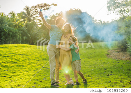 Pregnant mom, dad and son at the gender party on the golf course release blue smoke. Gender reveal announcement on the golf course. Loving family expecting baby boy. Happy moments Pregnant mom, dad and son at the gender party on the golf course release blue smoke. Gender reveal announcement on the golf course. Loving family expecting baby boy. Happy moments 102952269