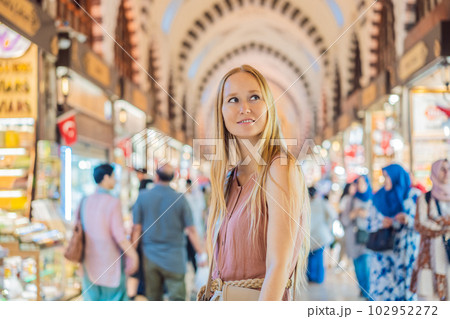A tourist woman walks among the countless shops at the Grand Bazaar and Egyptian Bazaar in Istanbul. Shopping and travel in Turkey concept. Istanbul historical Egyptian Bazaar. Misir Carsisi, spice 102952272