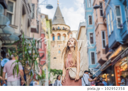 Portrait of beautiful woman tourist with view of Galata tower in Beyoglu, Istanbul, Turkey. Turkiye Portrait of beautiful woman tourist with view of Galata tower in Beyoglu, Istanbul, Turkey. Turkiye 102952358
