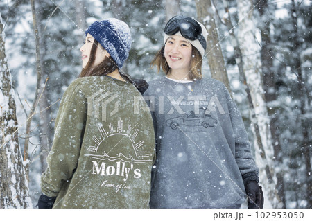 雪の降るスキー場でポーズをするスノボ女子　女子旅 102953050