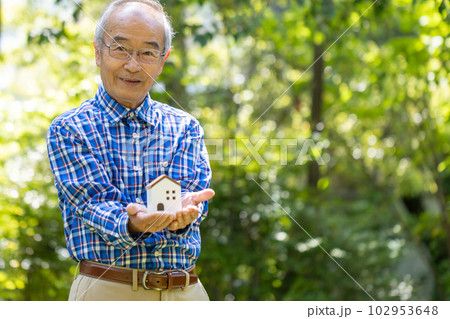 木でできた小さなおうちを手に持っている元気な一人のシニア男性 木でできた小さなおうちを手に持っている元気な一人のシニア男性 102953648