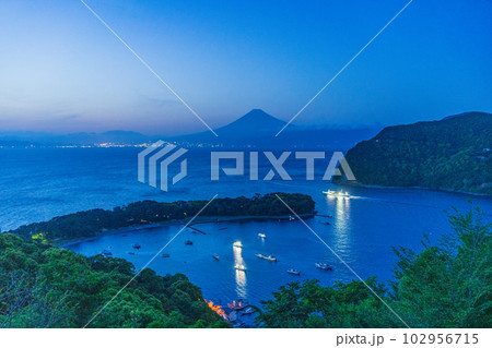 （静岡県）陽が落ちて、富士山を背に遠洋漁業に向かう戸田の漁船団 102956715