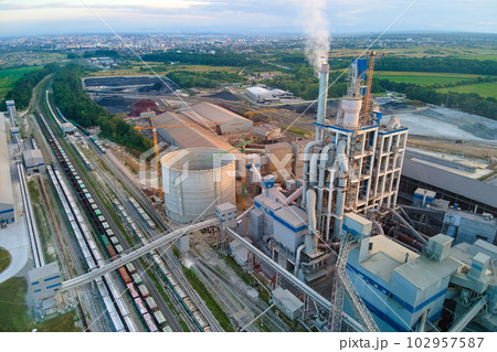 Aerial view of cement factory with high concrete plant structure and tower crane at industrial production site. Manufacture and global industry concept. 102957587