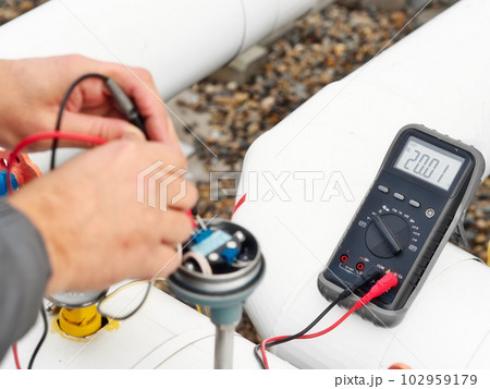 Checking gas equipment sensor with multimeter. Close-up hands. Diagnostics of industrial equipment Checking gas equipment sensor with multimeter. Close-up hands. Diagnostics of industrial equipment 102959179