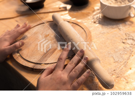 Chef hands and a wooden rolling pin, bakery equipment 102959638