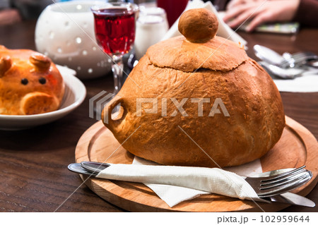 Bread bowl soup stands on a table, close up photo 102959644