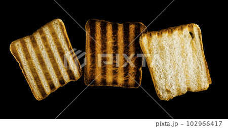 Three slices of toasted bread on the grill on a black background. Toast bread. 102966417