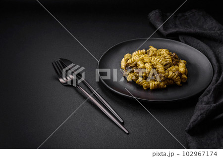 Delicious fusilli pasta with green pesto sauce, with salt and spices Delicious fusilli pasta with green pesto sauce, with salt and spices 102967174
