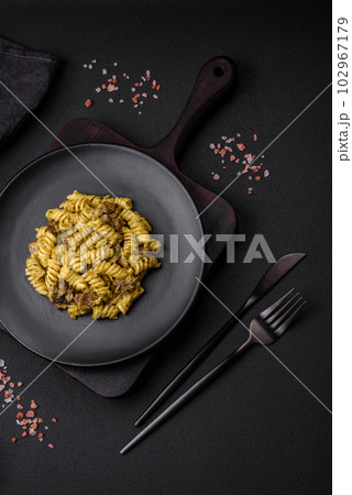 Delicious fusilli pasta with green pesto sauce, with salt and spices 102967179