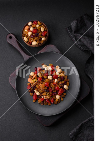 Mix of roasted cashews, hazelnuts and walnuts with dried cranberries and raisins 102967213