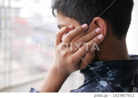 teenage boy having ear pain touching his painful ear , teenage boy having ear pain touching his painful ear , 102967911