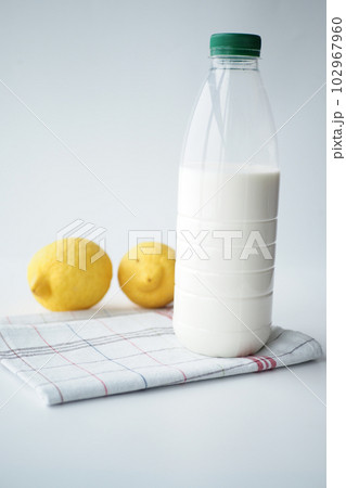 bottle of milk and yellow lemon on white background  102967960