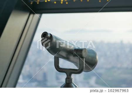 Coin-operated binoculars looking out over city , 102967963