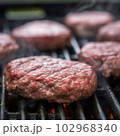 Delicious hamburger patty on grill 102968340