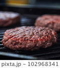 Delicious hamburger patty on grill 102968341
