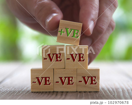 Hand stacking on wooden blocks with positive sign on top. Positivity and negativity concept 102970678