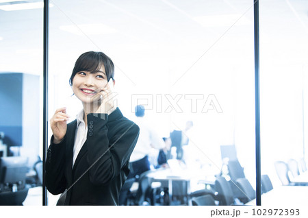 女性　電話　スマホ　オフィス　笑顔 102972393