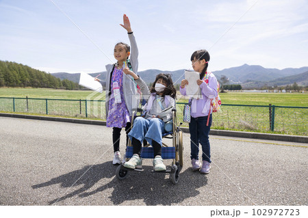 遠足　女子小学生 車いすに乗った女の子と学校の遠足に行く小学生の友達の写真素材 [102972723] - PIXTA