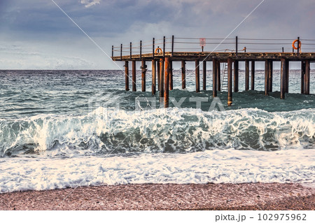 Storm in the Mediterranean Sea, Turkey, strong waves near the old wooden pier 102975962