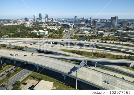Aerial view of american freeway intersection with fast moving cars and trucks. USA transportation infrastructure concept Aerial view of american freeway intersection with fast moving cars and trucks. USA transportation infrastructure concept 102977563