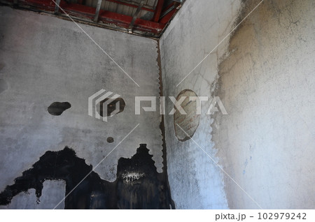 old scary interior burn house, cement wall and wood floor 102979242